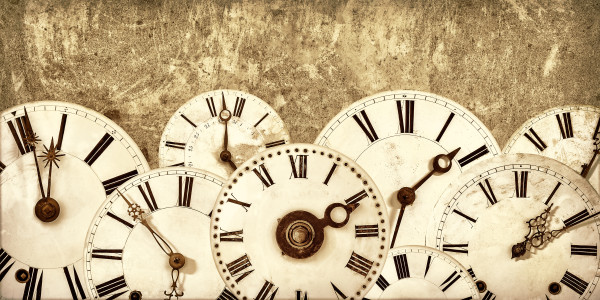 Various vintage clock faces in front of an old wall