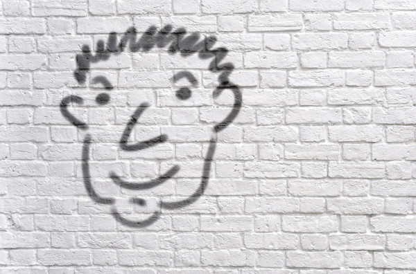 Head graffiti on a white brick wall