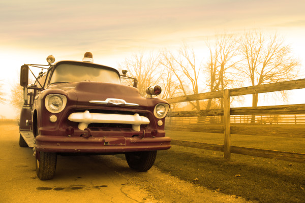 Classic fire truck by the fence in sepia