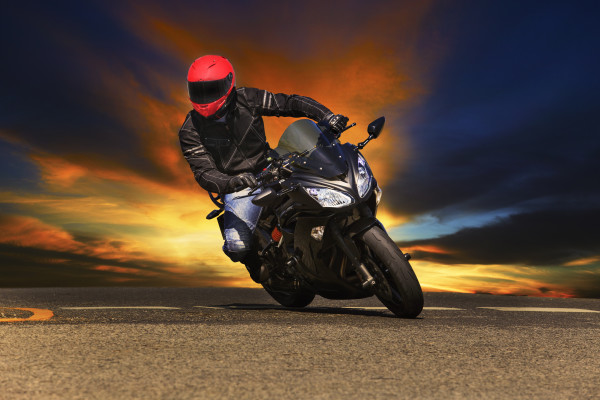 young man riding big bike motorcycle on asphalt roads against beautiful dusky sky use for sport leisure and male activities theme