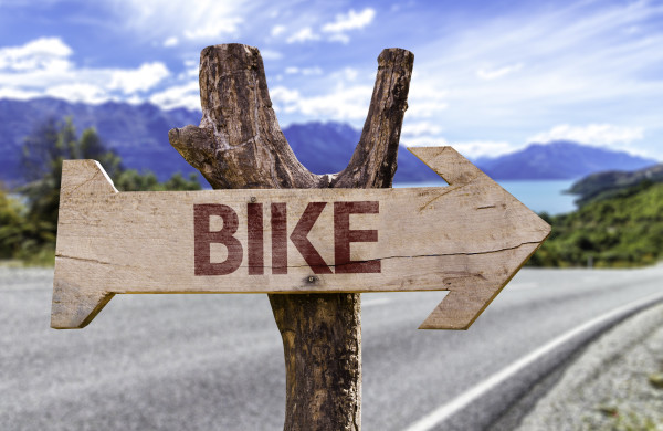 Bike wooden sign with a street background