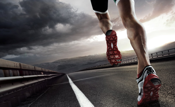 Sports background. Runner feet running on road closeup on shoe.