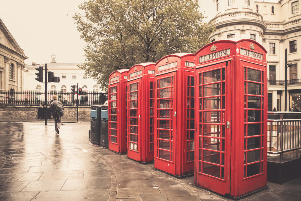 Vintage style  red telephone booths on rainy street in London