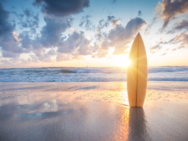 Surfboard on the beach at sunset