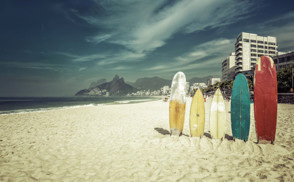 Surfboards standing upright in bright sun on the beach at Ipanem