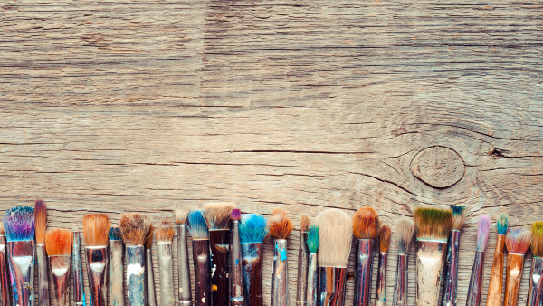 Row of artist paintbrushes closeup on old wooden rustic backgrou