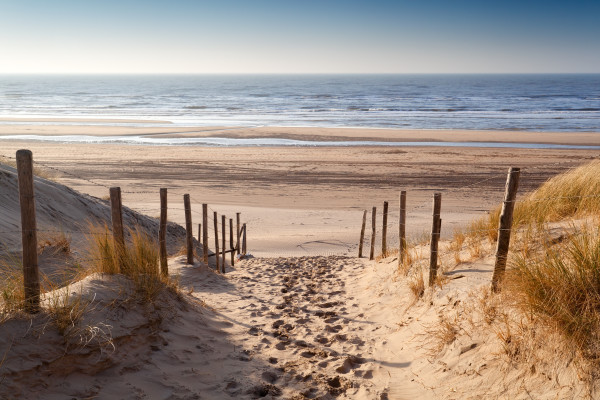 sand path to North sea at sunset