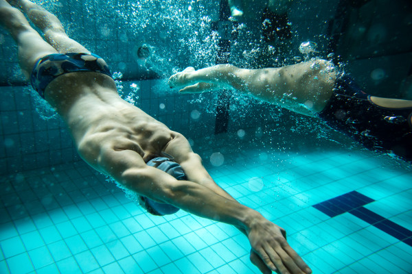 Swimmers at the swimming pool.Underwater photo.