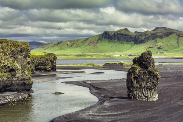 The black sand beach with typical Icelandic mountain landscapes