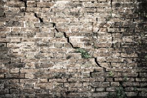 Cracked brick wall   Deep crack in a brick wall   toned image