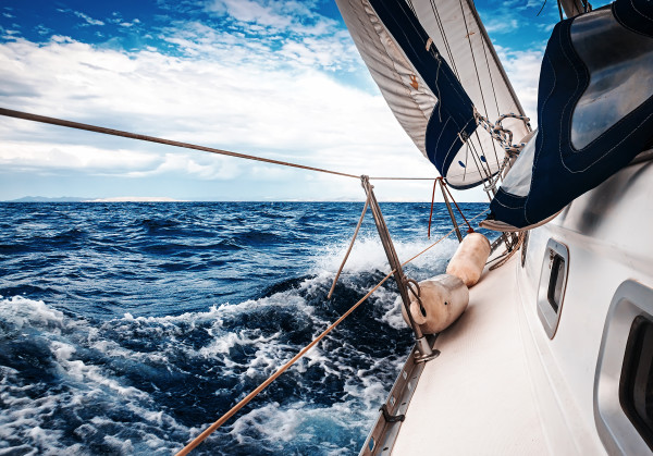 The white sails of yachts on the background of sea and sky in the clouds