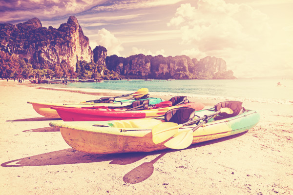 Retro toned kayaks on a tropical beach.