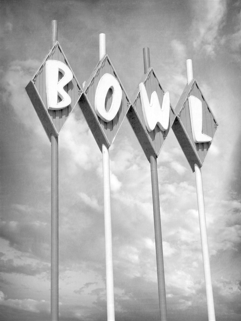 aged and worn vintage black and white photo of bowl neon sign