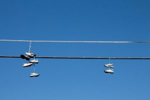 Shoes hanging on a wire against blue sky