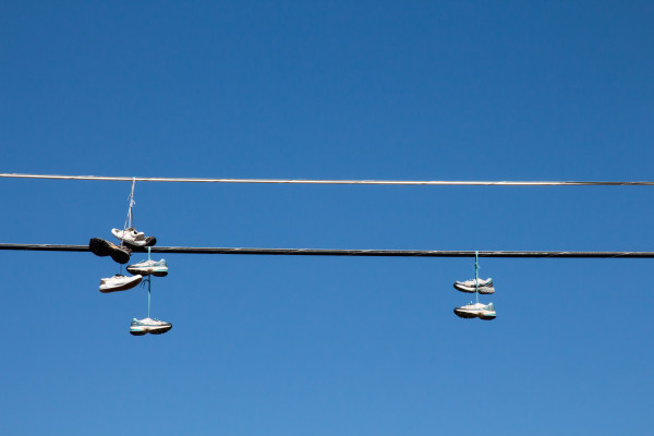 Shoes hanging on a wire against blue sky