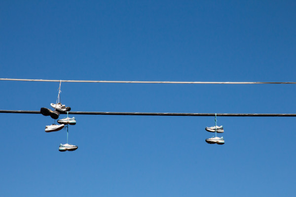 Shoes hanging on a wire against blue sky