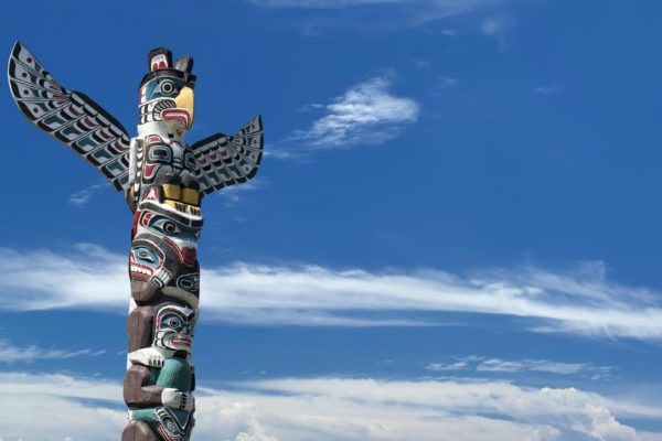 Totem wood pole in the blue cloudy background